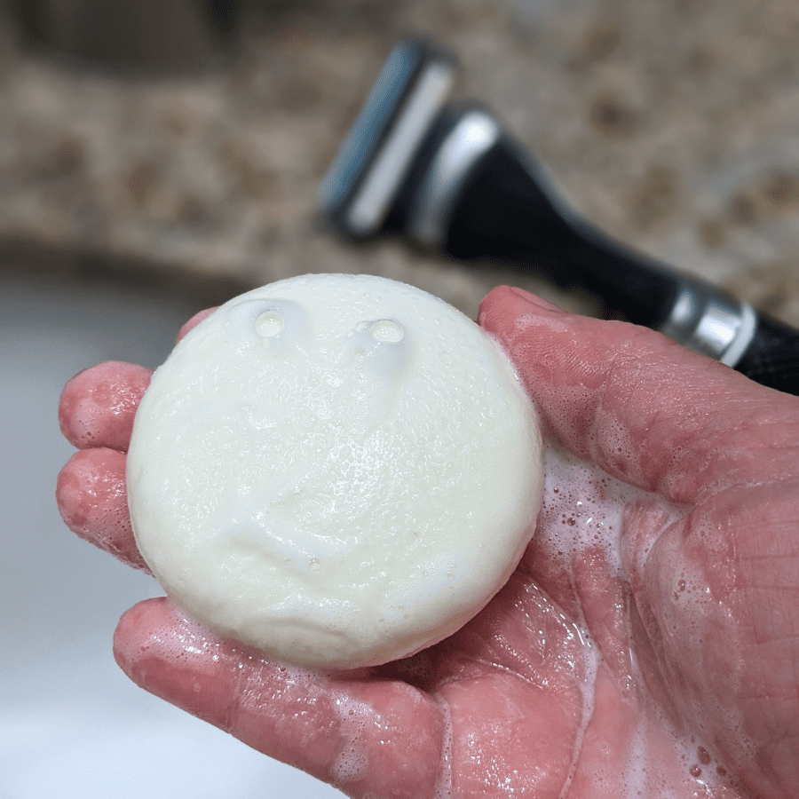 Tangie Unscented Shave Cream Bar lathering in hand with bubbles, showing its creamy, foamy texture for a smooth, zero-waste shave