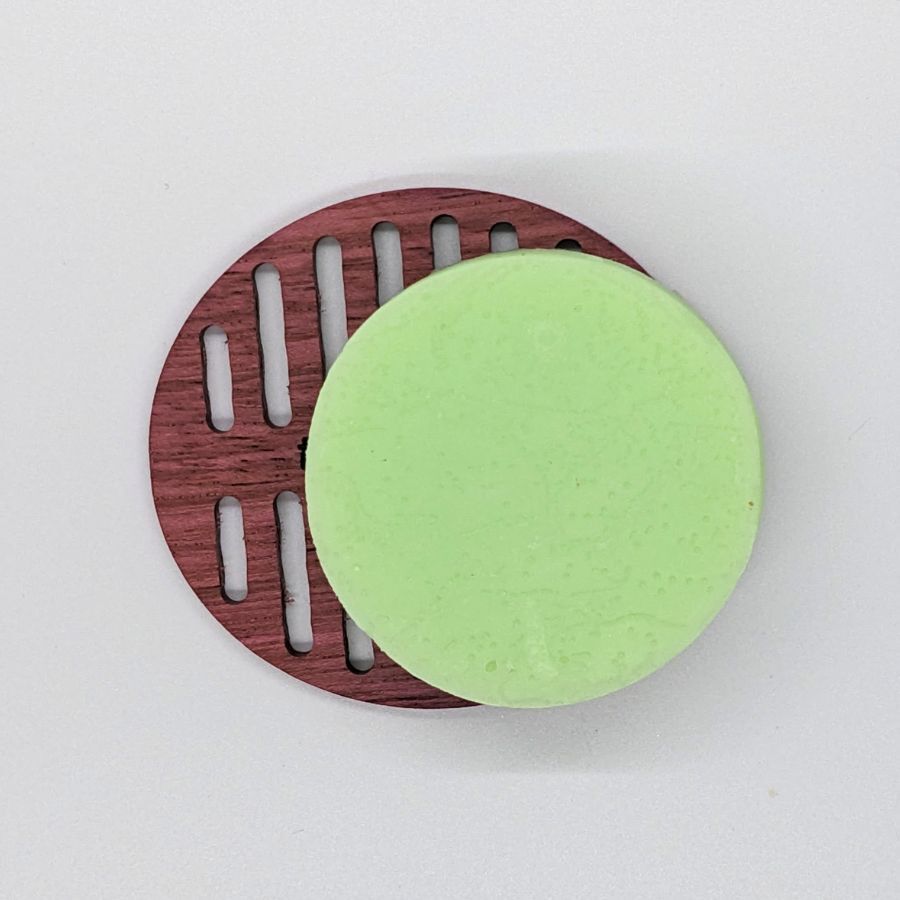 Tangie Pet conditioner Bar sitting on a drying disk emphasizing how to allow the bar to dry between uses for extended bar life.