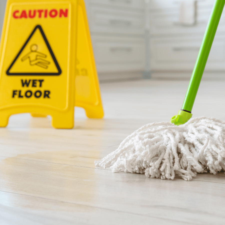 Cotton mop head on wet floor with caution sign, ideal for Tangie Floor Cleaner use