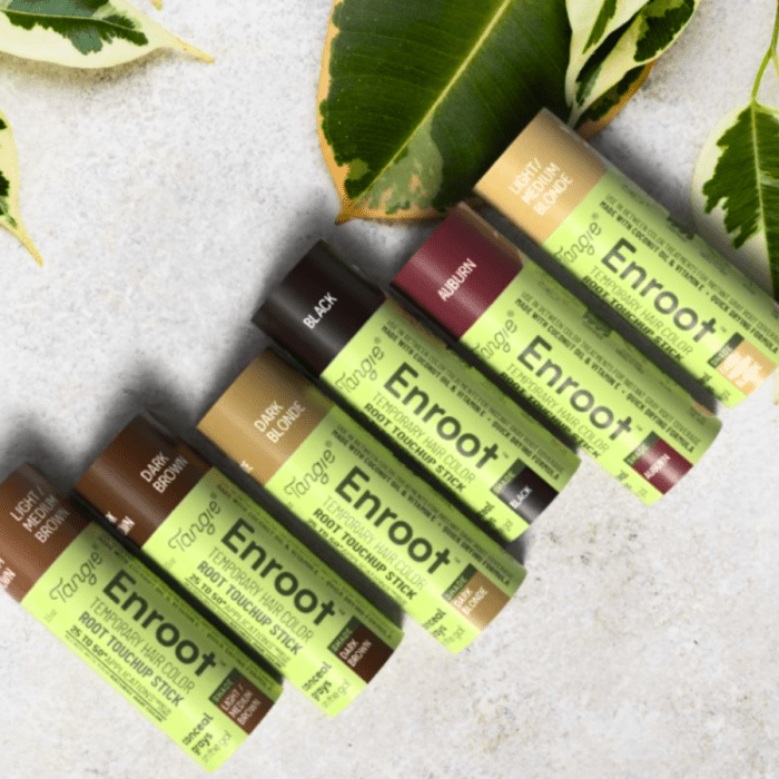 Enroot Temporary Root Touchup Stick tubes in all six shades, arranged in a row on a neutral surface with fresh greenery, highlighting the eco-friendly packaging.