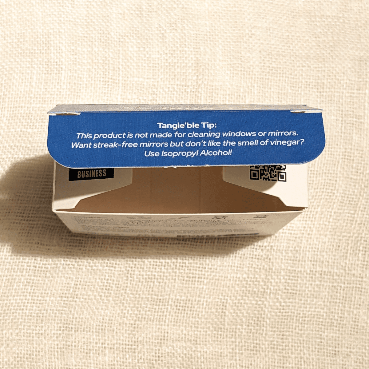 Close-up of Tangie’s all-purpose cleaner packaging showing a Tangie'ble Tip about streak-free mirrors.