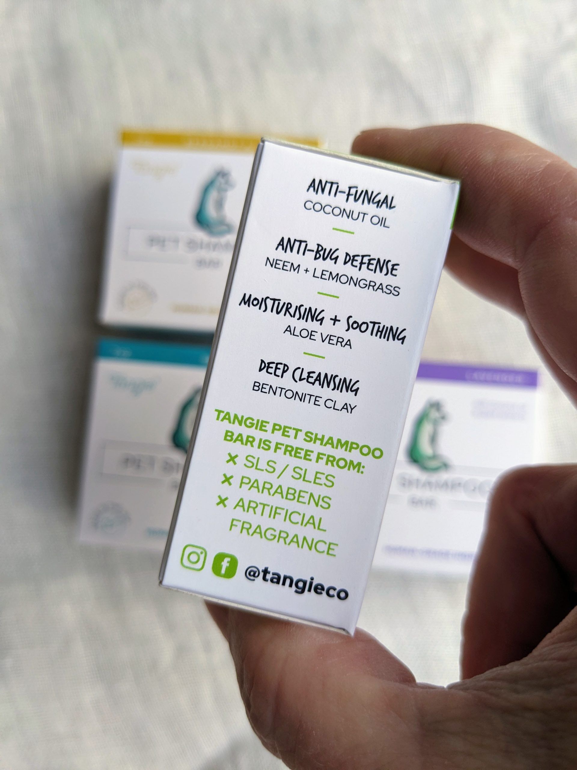 Tangie Pet Shampoo Bar side panel highlighting the ingredients not included, such as SLS, parabens, and artificial fragrances, with eco-friendly certifications.