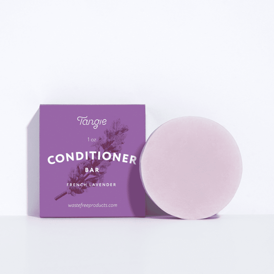 Lavender conditioner bar next to eco-friendly purple box packaging, ideal for dry or damaged hair, part of a BOGO offer from Tangie.
