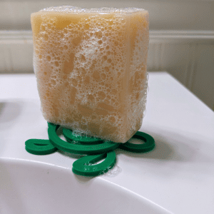 Tangie Turtle Drying Disk with wet soap bar on bathroom sink showing drainage and durability