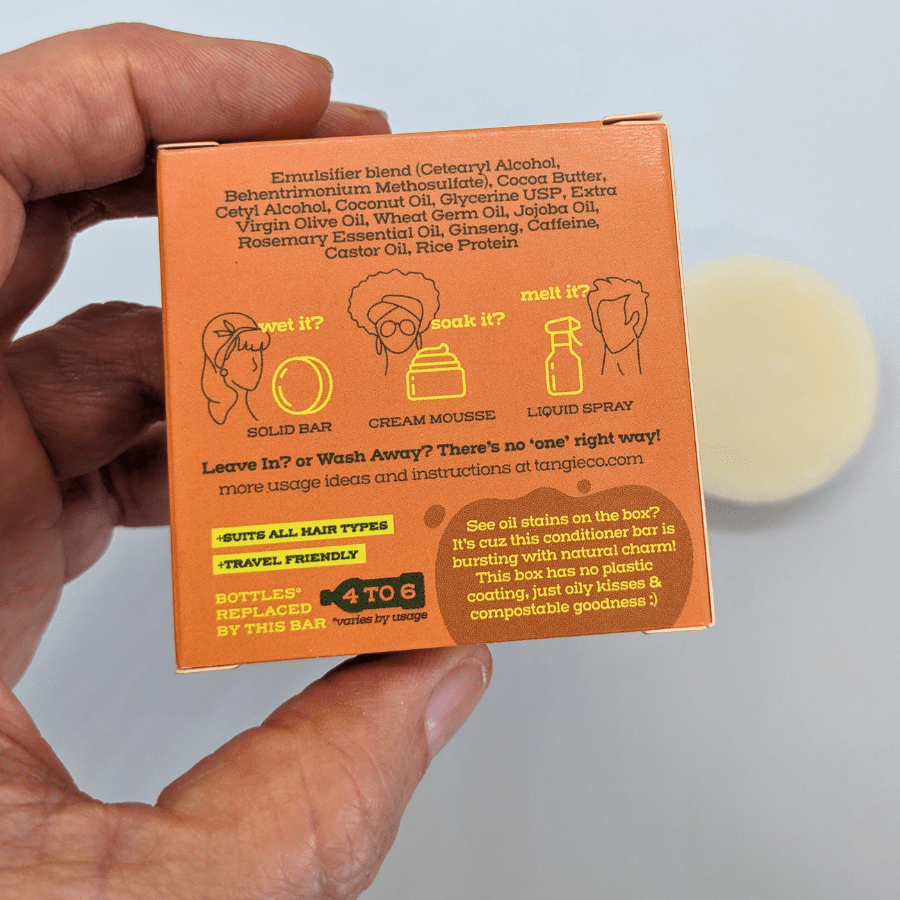 Natural superfoods conditioner bar by Tangie, shown with back of eco-friendly box held in hand and the conditioner bar in the background.