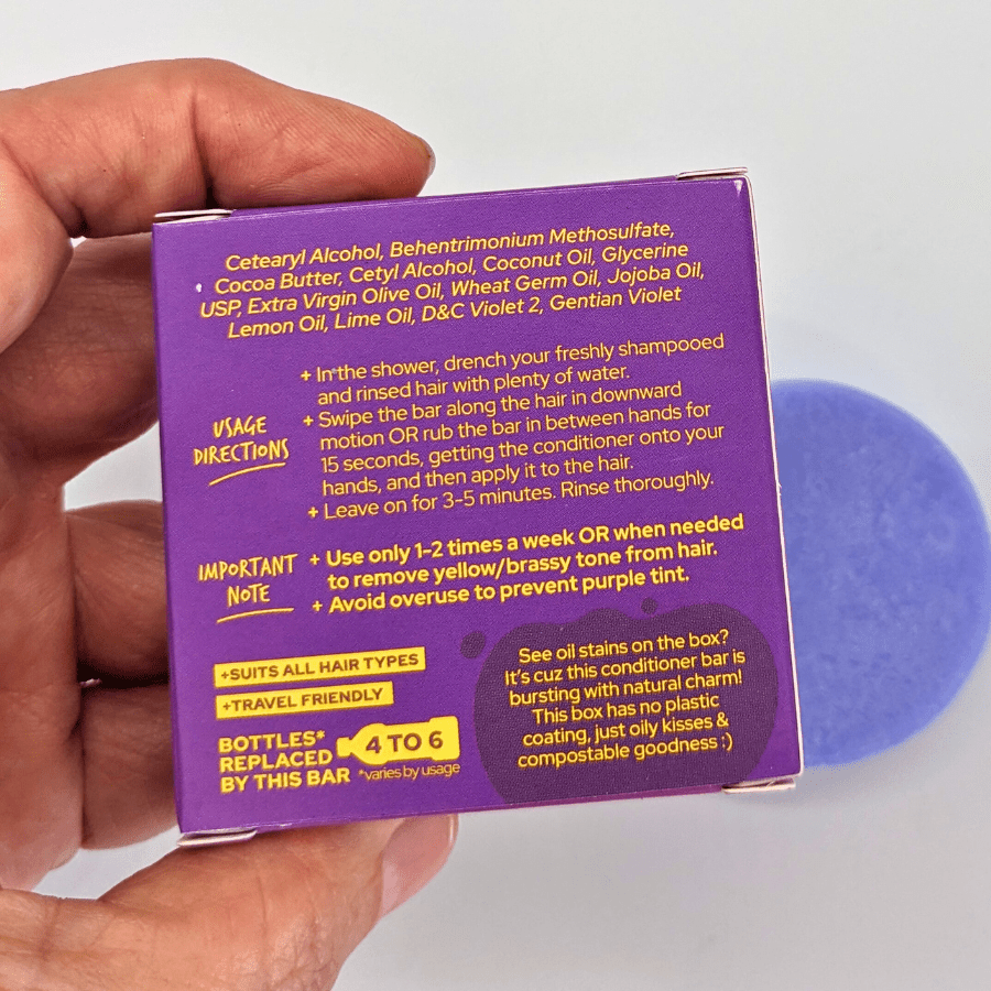 Hand holding Tangie Fixtone Purple Conditioner Bar box with purple bar — neutralizes yellow/brassy tones on blonde, gray & silver hair
